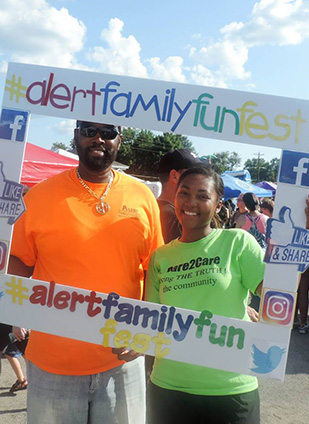 A man and woman holding up a sign at the Family Fun Fest 2018